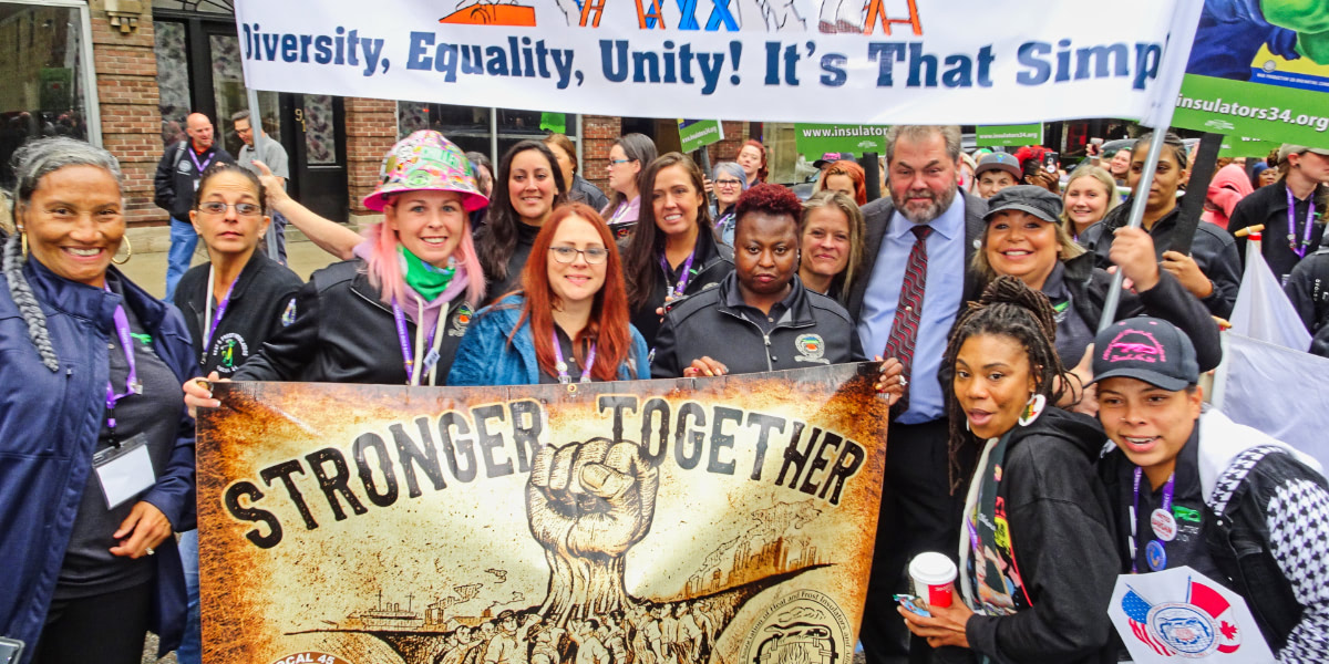 Group photo of female construction workers at the Women Build Nation conference holding a Stronger Together banner